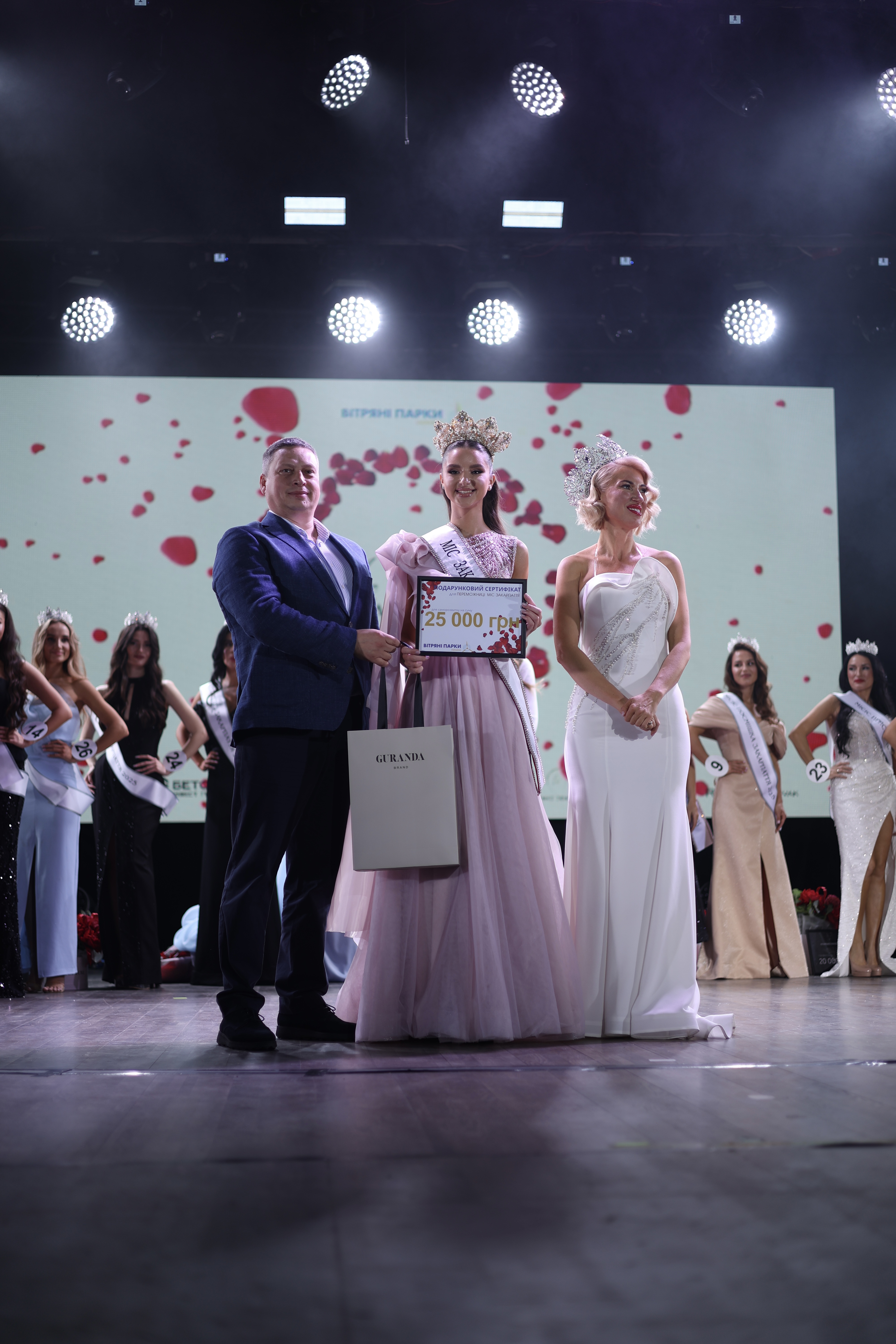 Андрея Гуледза отримує подарунковий сертифікат від Вітряних парків України на сцені фіналу